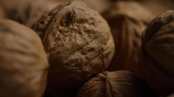 Cinematic, rotating shot of walnuts in their shells on a white surface - WALNUTS 092 video