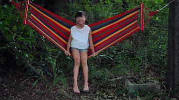 Little girl resting lying on hammock outdoors in slow motion video