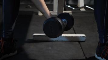 Joven mano sujetando pesas hasta ejercicios en el gimnasio fitness video