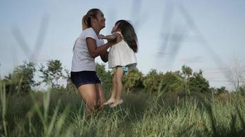 Slow motion of young mother throwing his adorable daughter in the air video