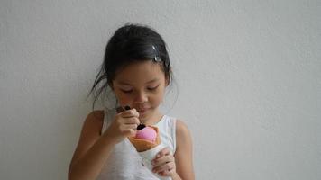 süßes kleines Mädchen, das Eis isst und großes Lächeln