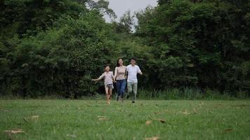 Slow motion of parents with daughter running enjoy in the park  video