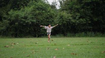 câmera lenta, menina feliz correndo e sorrindo no parque