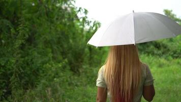 vrouw lopen hand met witte paraplu onder regen video