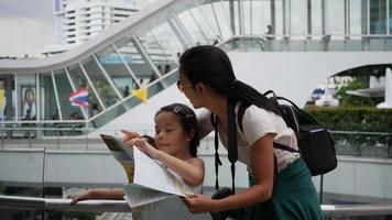 Mutter und Tochter betrachten eine Karte, während sie in der Stadt reisen video