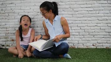 mamma och dotter läser roliga historier. video