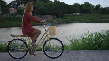 donna in sella a una bicicletta nel parco video