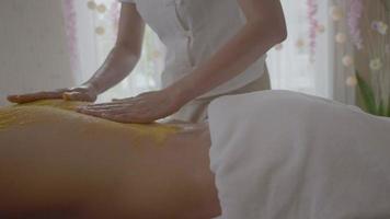 jonge man krijgt een zout scrubbehandeling in de spa-aromatherapie video