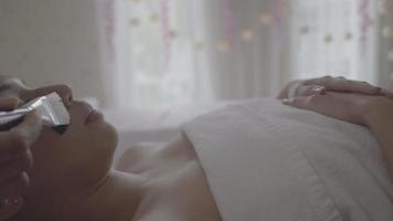 Young beautiful woman receives charcoal spa therapy