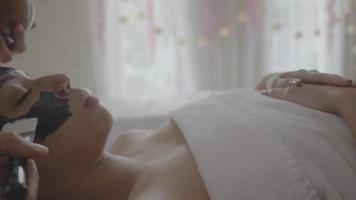 jonge mooie vrouw ontvangt houtskool spa-therapie video