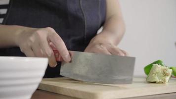 Close up of chief woman making salad healthy food and chopping bell pepper on cutting board. video