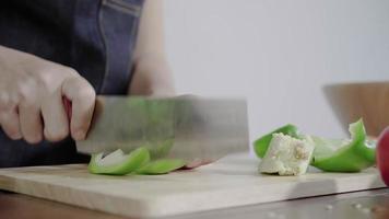 Close up of chief woman making salad healthy food and chopping bell pepper on cutting board. video