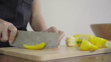 Close up of chief woman making salad healthy food and chopping bell pepper on cutting board. video