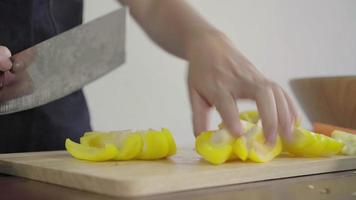 Close up of chief woman making salad healthy food and chopping bell pepper on cutting board. video