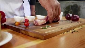 Close up of gourmet chef or cook seasoning fresh chunk of deli piece of beef with sea salt and grounded spicy peppers. video