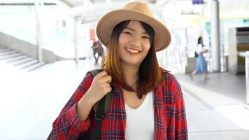 attraente giovane donna asiatica sorridente ritratto all'aperto nella serie di persone reali della città. ritratto di moda stile di vita all'aperto di ragazza asiatica sorridente felice. concetto di ritratto di felicità all'aperto di estate. video