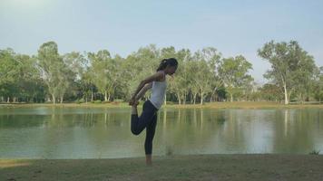 joven mujer asiática yoga al aire libre mantenga la calma y medite mientras practica yoga para explorar la paz interior. el yoga y la meditación tienen buenos beneficios para la salud. deporte de yoga y concepto de estilo de vida saludable. video