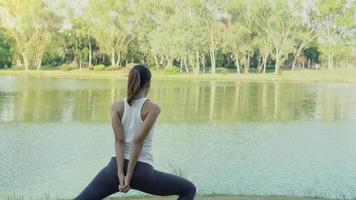 jonge Aziatische vrouw yoga buitenshuis blijf kalm en mediteert tijdens het beoefenen van yoga om de innerlijke rust te verkennen. yoga en meditatie hebben goede voordelen voor de gezondheid. yoga sport en een gezonde levensstijl concept. video