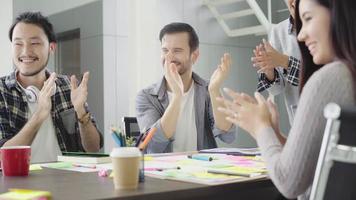 grupo de empresários vestidos casualmente, discutindo ideias no escritório. profissionais criativos reunidos na mesa de reunião para discutir as questões importantes do novo projeto de startup de sucesso video