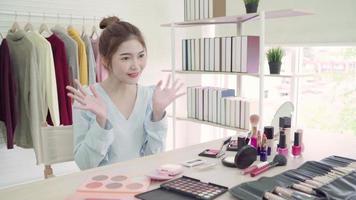 Beauty-Blogger präsentieren Beauty-Kosmetik vor der Kamera für die Videoaufnahme. schöne asiatische Frau verwenden Kosmetik, während Bewertung Make-up Tutorial Live-Video zu sozialen Netzwerk über das Internet übertragen. video