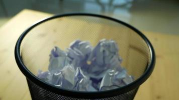 Close up of white crumpled paper being thrown into a trash bin video