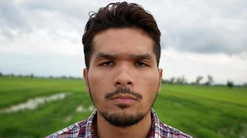 Close up of a man with a serious expression while he is alone in a field video