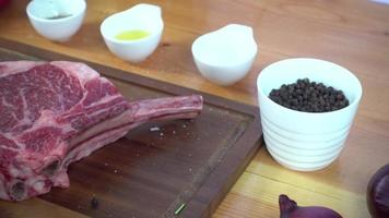 close-up van gastronomische chef-kok of kok kruiden vers stuk deli stuk rundvlees met zeezout en geaarde pittige paprika's. video