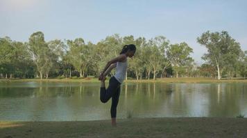 joven mujer asiática yoga al aire libre mantenga la calma y medite mientras practica yoga para explorar la paz interior. video