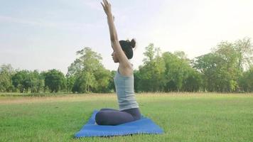 ung asiatisk kvinnayoga utomhus håller sig lugn och mediterar medan de tränar yoga för att utforska den inre freden. video