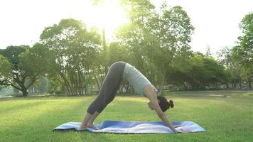 joven mujer asiática yoga al aire libre mantenga la calma y medite mientras practica yoga para explorar la paz interior.