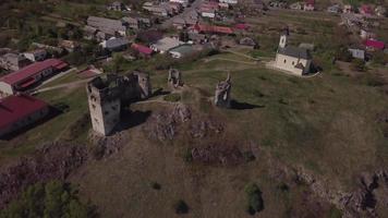 Drohne fliegt von alten Burgruinen und einer Kirche in 4k video