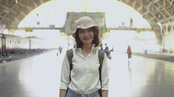 Happy Asian woman waiting the train at train station for travel in summer. video
