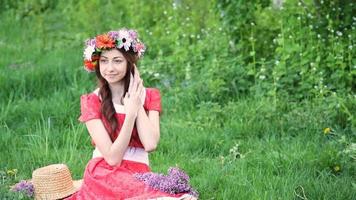 hermosa mujer con corona recoge flores en la pradera. mujer feliz en primavera o verano. me encanta trabajar con plantas video