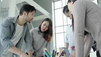 Group of casually dressed business people discussing ideas in the office. video