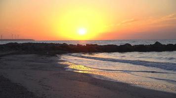 4k escénico amanecer rojo sol de fondo. video de cerca del sol naciente detrás del mar