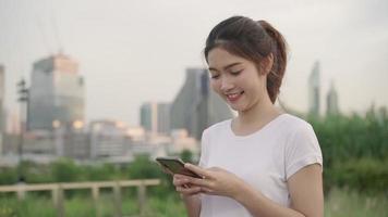 Slow motion - Cheerful Asian tourist blogger woman using smartphone for direction and looking on location map. video