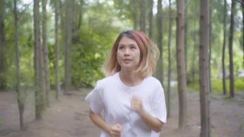 Slow motion - Healthy beautiful young athletic sporty Asian runner woman in sports clothing running. video