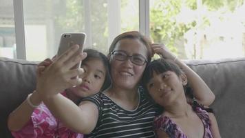 Aziatische en gelukkige familie die selfie met smartphone nemen. video