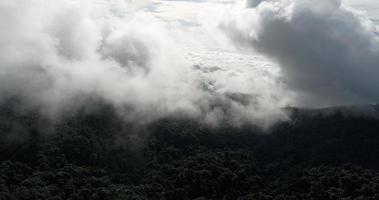 Luftbild Weitwinkel Berg mit üppigen Bäumen und nebligen Wolken video