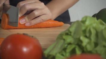 close-up de uma mulher cortando uma cenoura