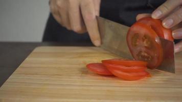 chef cortando un tomate video