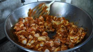 gebratenes Huhn mit Curry in der Pfanne, um thailändisches Essen zu machen. video