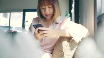 asiatisk kvinna som använder smartphonen