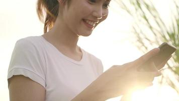 Cheerful Asian tourist blogger woman using smartphone for direction and looking on location map while traveling. video