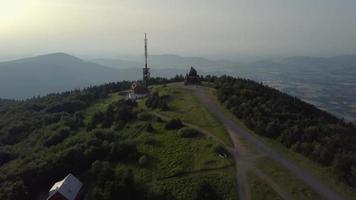 drone voando em direção a uma torre de rádio e igreja em 4k video