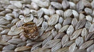 Accesorio de anillos de boda acostado sobre una mesa de paja video