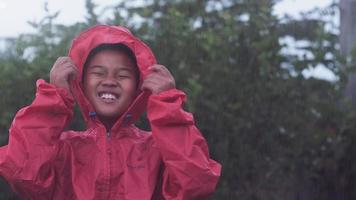 niño jugando bajo la lluvia video