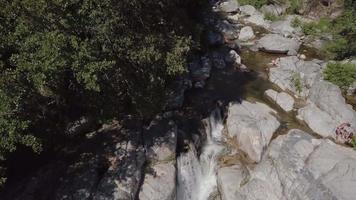 Drone descending to a waterfall on a sunny summer day in Corsica video