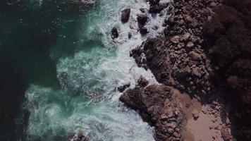 drone vliegt over een strand met golven in 4k video