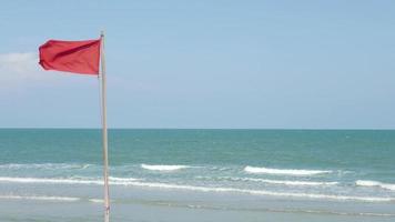 flagrande röd flagga på stranden video